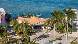 A coastal property with a large building, palm trees, and a view of the sea. - Infinite Views! Heated Pool! Directly on Tampa Bay (Holmes Beach)