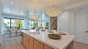Un'ampia cucina con una grande isola, mobili in legno e un moderno lampadario.