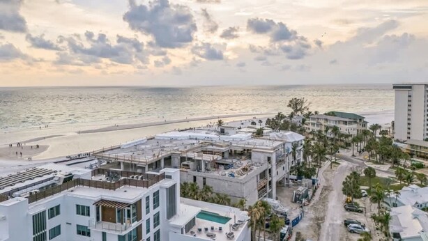 Ett hotell vid kusten med en pool på taket, direkt tillgång till stranden och modern arkitektur.