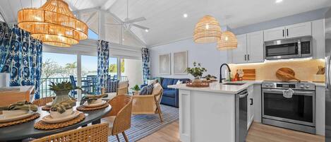 Una cocina moderna con muebles blancos, electrodomésticos de acero inoxidable y una isla central.