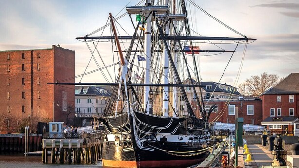 A tall ship docked at a pier with buildings in the background. - Boston Condo with Free Parking (Boston)