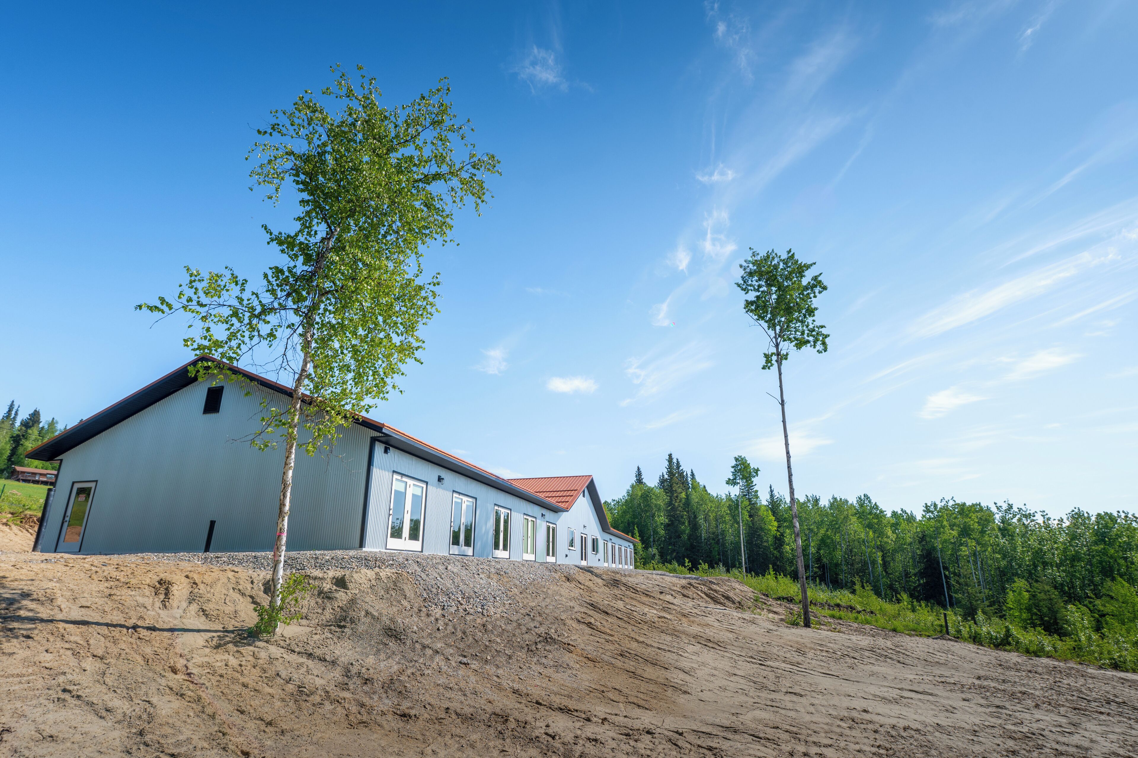 A single-story building with a sloped roof, a door, and a window on the side.