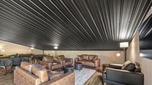 Un intérieur moderne avec des canapés en cuir, un coin repas et un design de plafond original.