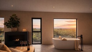 Una habitación moderna con chimenea, una bañera grande y vistas a un paisaje al atardecer.