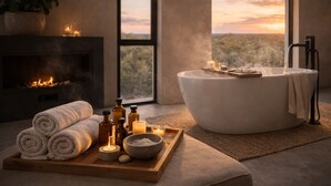 Un cuarto de spa con una bañera grande, chimenea y vistas al paisaje desértico.