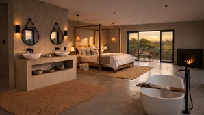 Un dormitorio moderno con una cama grande, una bañera, un tocador con lavamanos y una chimenea.