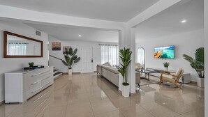 Un salon moderne avec un canapé, une table basse et un téléviseur fixé au mur.