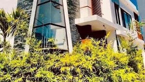Un edificio moderno con fachada de vidrio llamativa y pared de acento de piedra.