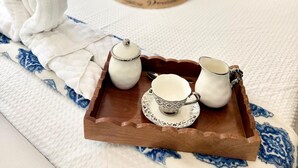 Una cama bien hecha con una bandeja de té y toallas.