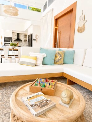 A modern living room with a white sofa, a wooden coffee table, and a magazine titled 'Beach Life.' - Villa Serena| 4 Suites, Pool, Terrace & Corner Lot (Sosúa)