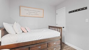A bedroom with a wooden bed, white bedding, and a motivational quote on the wall. - Mimosa Mornings  Home for 12 (Rocky Mount)