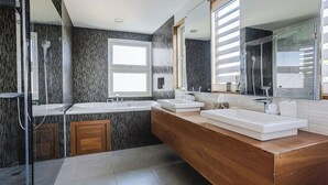 A modern bathroom with two sinks, a large mirror, and a shower area. - Oceanfront 2BR at Ultravioleta Cabarete | Fast WiFi, Balcony & Parking (Cabarete)