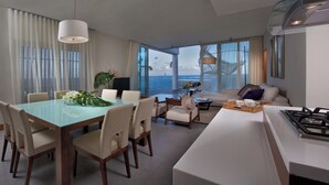 Una sala de estar moderna con un sofá, una mesa de comedor con sillas y una zona de cocina con estufa.