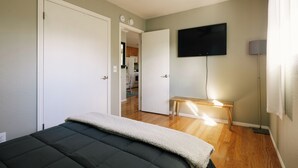 Ein Schlafzimmer mit einem Bett, einem Fernseher und einem Schreibtisch mit Lampe.