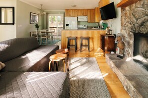 A cozy living room with a sofa, a coffee table, and a fireplace. - Peaceful Mountain Sanctuary w/central heat,AC,fireplace near Arrowhead Village (Lake Arrowhead)