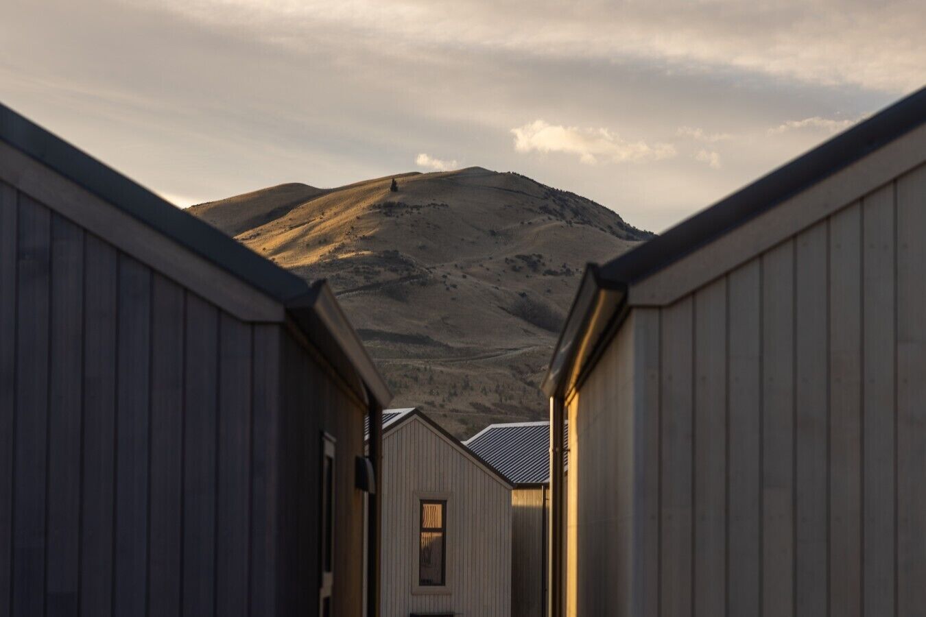 A row of buildings with a mountain in the background.