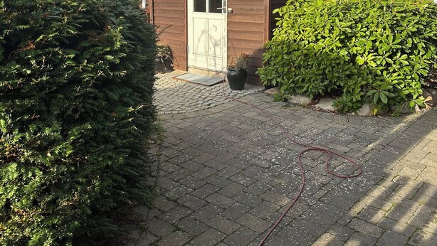 A house with a front door, a small window, and a paved driveway. - Spacious holiday home near beach and nature (Jægerspris)