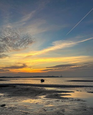 A sunset over a body of water with a distant city skyline.