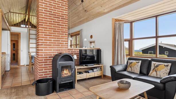 Una sala de estar acogedora con chimenea, un sofá, un televisor y un comedor.