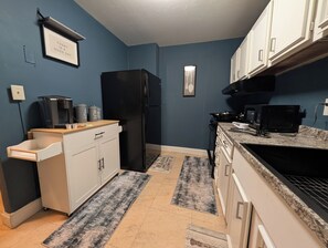 A kitchen with a refrigerator, microwave, coffee maker, and a coffee dispenser. - Urban Oasis Luxe King Suites  City Views (Atlanta)