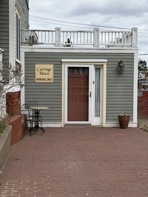 A building with a sign reading 'Carriage House PARKING ONLY' and a brown door. - Carriage @ Hendrickson House (Bayfield)