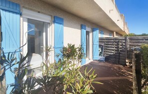 A house with blue shutters, a wooden deck, and a garden area with plants. - 2 bedroom lovely apartment in Fleury d'Aude (Fleury d'Aude)