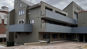 A multi-story building with a grey facade, balconies, and a sign reading "Village Center".