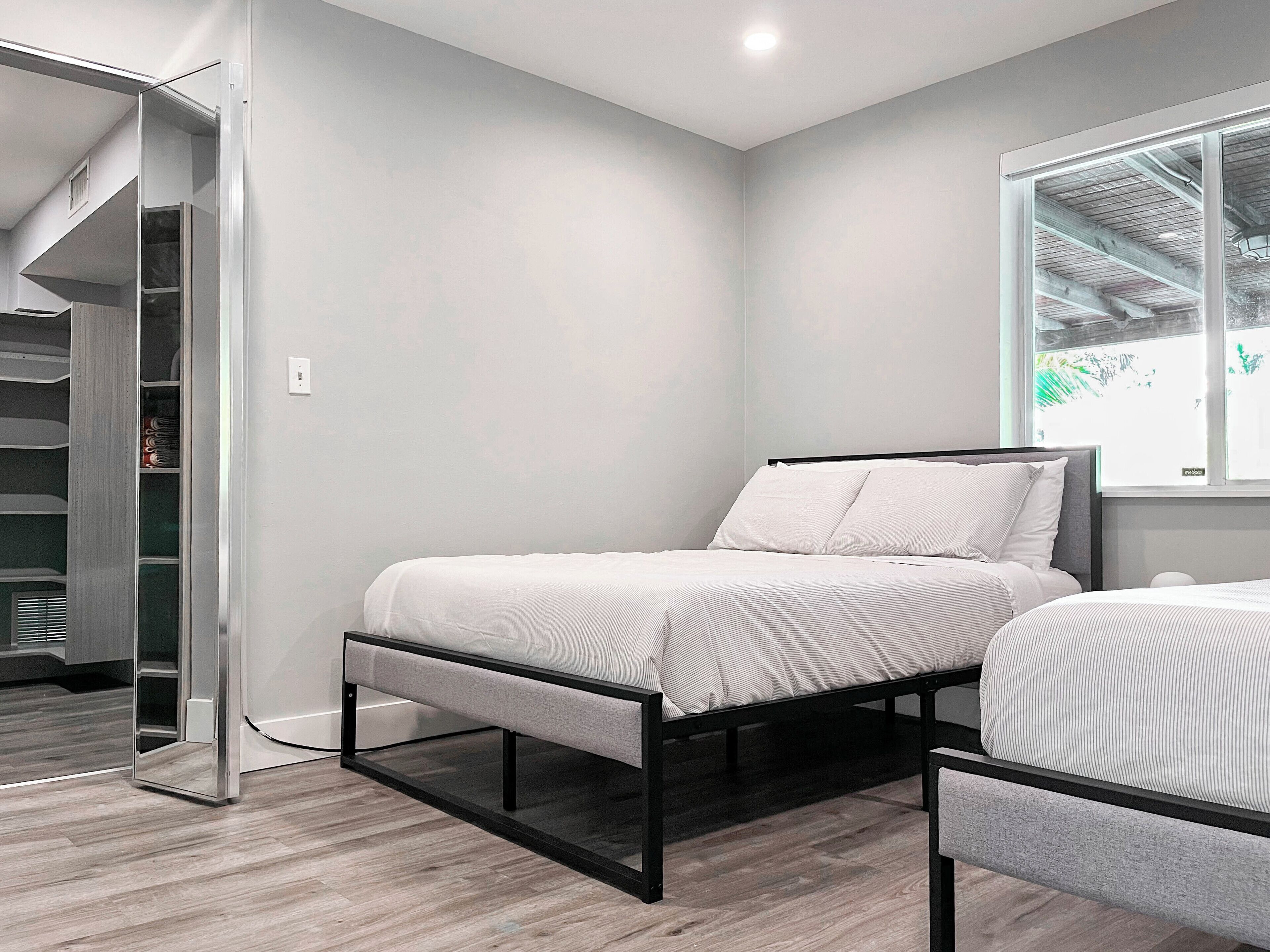 Een moderne slaapkamer met een bed, een stoel en een inbouwkast met planken.