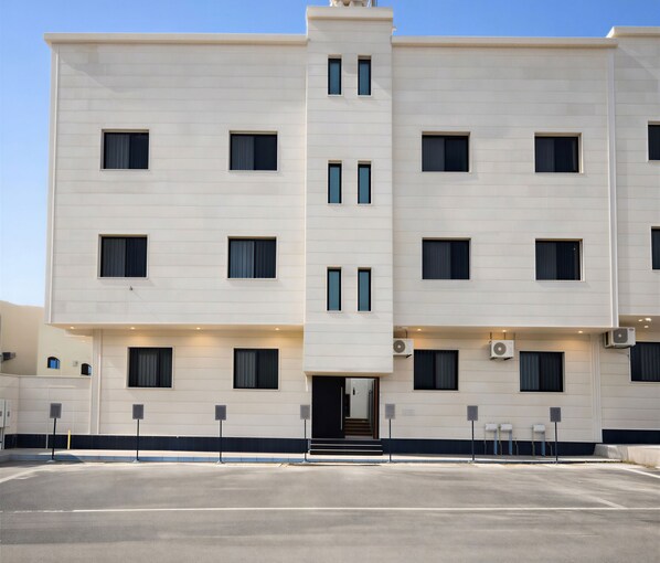 A multi-story hotel with a symmetrical facade, evenly spaced windows, and a central entrance. - Luxury apartments (Madinah)