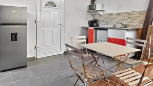 A compact kitchen with a refrigerator, microwave, and sink. - TERAKOTA Village Créole jacuzzis-plage (Deshaies)