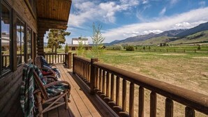 A wooden deck with a view of a mountainous landscape. - Copper Rose Ranch (Livingston)