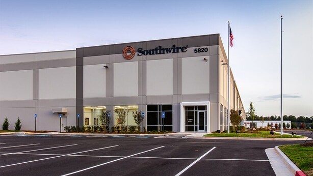 A Southwire building with a parking lot and a flag.