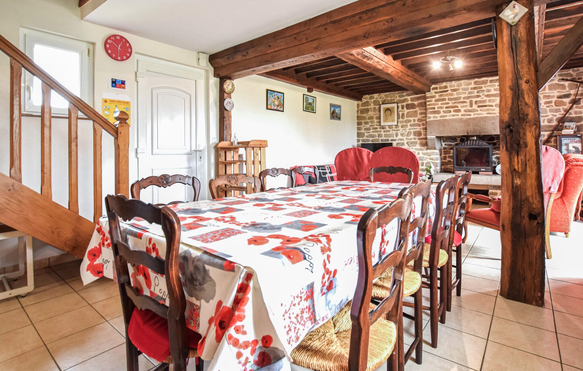 Un comedor con una mesa y sillas de madera, una pared de piedra y una chimenea.