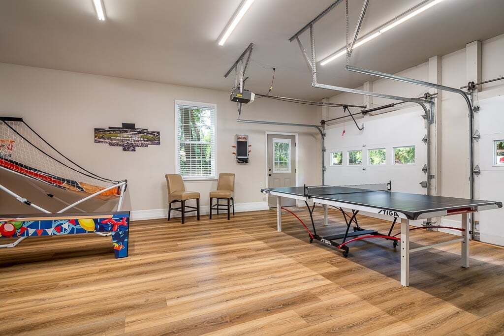 Une pièce équipée d’une table de ping-pong, d’un trampoline et de deux chaises.