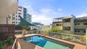 Una piscina en la azotea con vistas a los edificios circundantes.