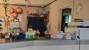 A room with a desk, a computer, and various decorative items including a globe and a snow globe. - Holiday Motel Ocala Downtown I-75 (Ocala)