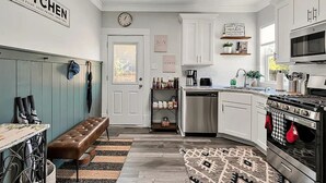 A modern kitchen with white cabinets, a built-in oven, and a coffee station. - 15 mins to Silos & Baylor | family home w/hot tub + yard (Waco)