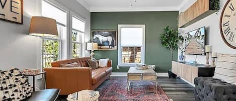 Living Room Retreat: Bright, stylish space with rustic charm and vibrant decor awaits your relaxation!