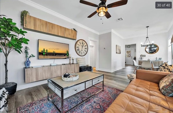 A modern living room with a sofa, coffee table, and a TV mounted on the wall.