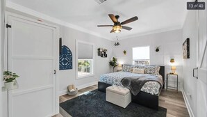 A bedroom with a bed, a ceiling fan, a window, and a door. - 15 mins to Silos & Baylor | family home w/hot tub + yard (Waco)
