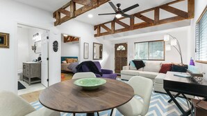 Un salón espacioso con techo de madera, una mesa de comedor redonda y un sofá.