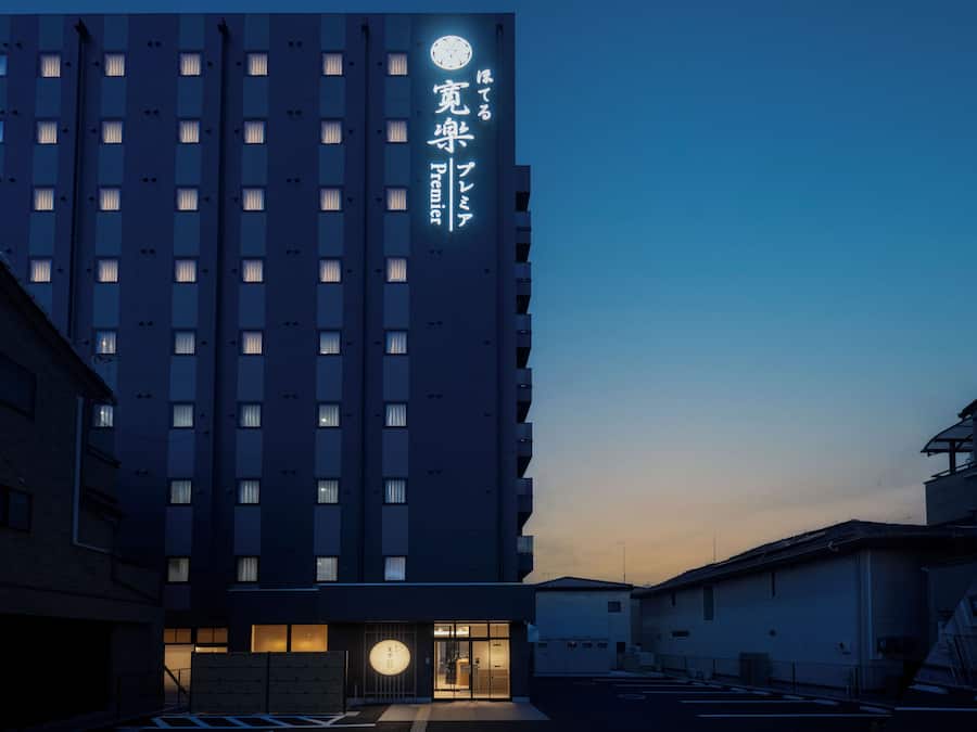 Um edifício de hotel com vários andares e um letreiro iluminado em destaque.