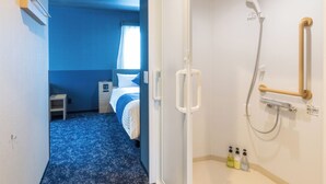 A hotel room with a shower, a bed, and a small table. - Hotel KAN-RAKU Premier Utsunomiya-Eki (Utsunomiya)