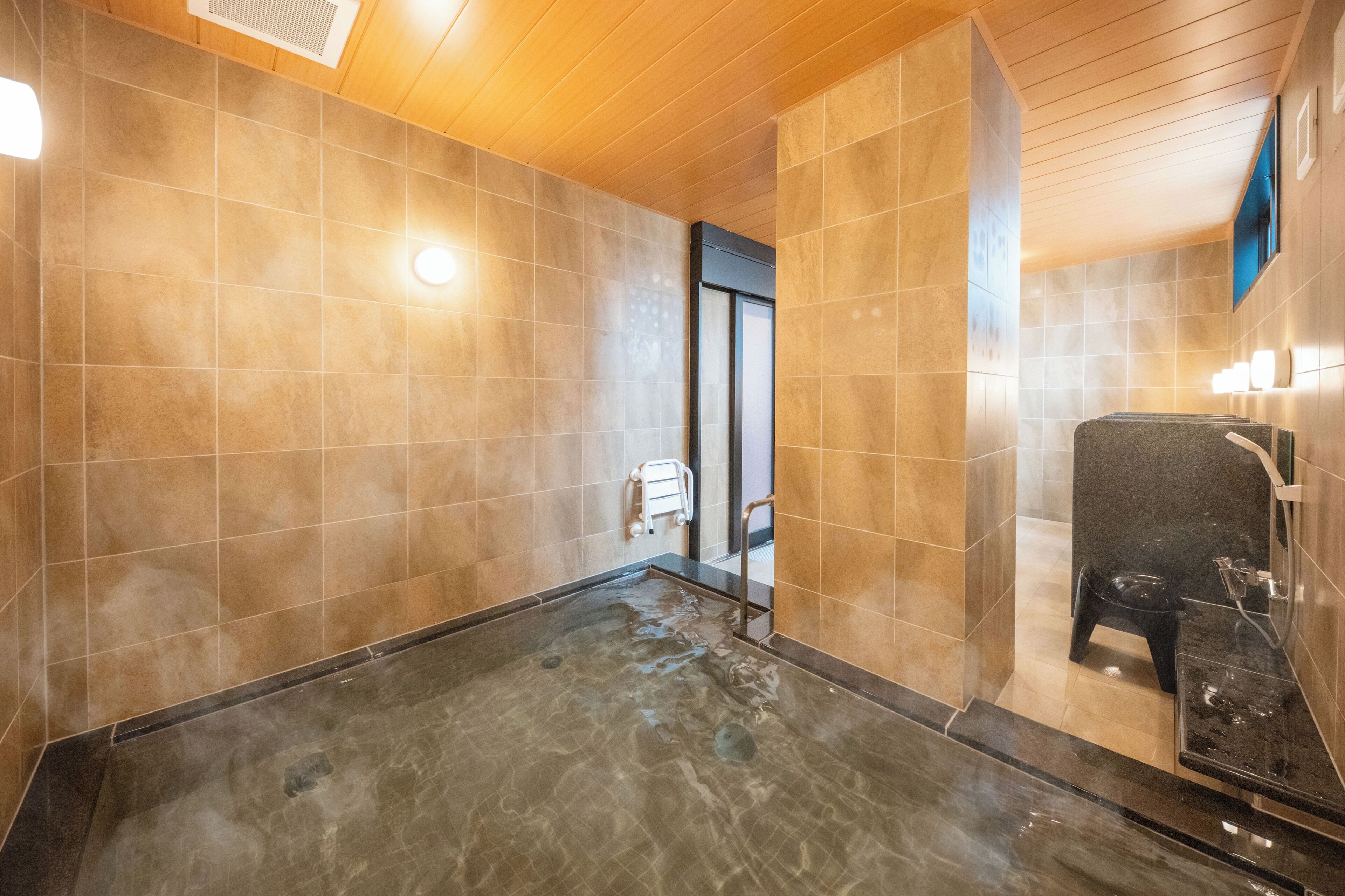 A modern bathroom with a large bathtub, a shower area, and a wooden ceiling.