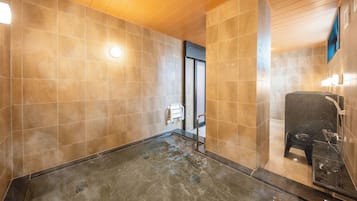 A modern bathroom with a large bathtub, a shower area, and a wooden ceiling.