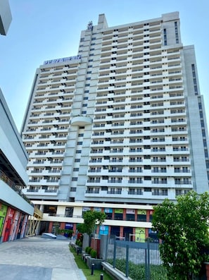 A multi-story building with a uniform facade, numerous balconies, and a clear sky. - Luxury 1BHK Retreat in Sector 106 - Pool, Gym & Premium Comfort (Gurugram)