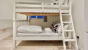A bunk bed with a ladder, a small window, and a flag pillow. - Station-side Top-floor Studio (London)