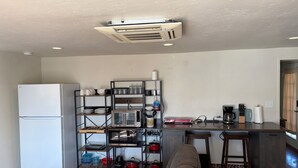 A compact kitchen with a built-in refrigerator, a coffee maker, and a toaster on the counter. - Large, well equipped Studio with Queen Bed and new bathroom. (Tucson)