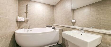 A bathroom with a bathtub, a sink, and a mirror.