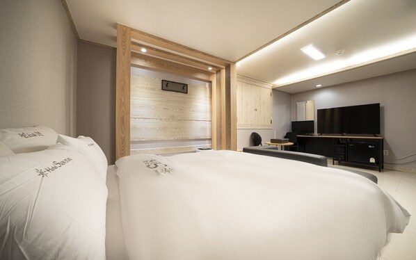 A modern hotel room with a large bed, a desk, a flat-screen TV, and a minibar. - Suwon Haenggung-dong Sunstar (Suwon)